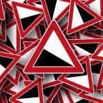 A pile of triangular warning signs with red borders, representing PPC mistakes.